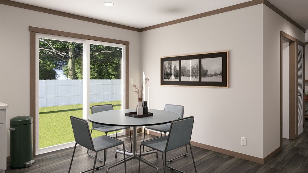 Small dining area with glass table, four chairs, large window, and wall art in a modern home.