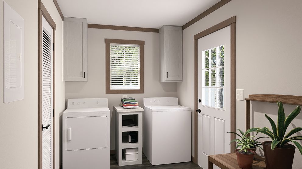 Bright laundry room with washer, dryer, cabinet storage, and a door to the outside.