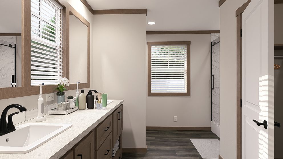 Bright modern bathroom with a double vanity, large mirror, and window blinds.