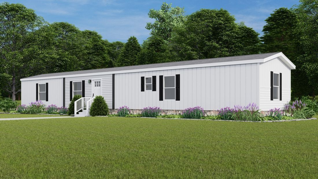 White manufactured home in a grassy yard with trees and purple flowers.
