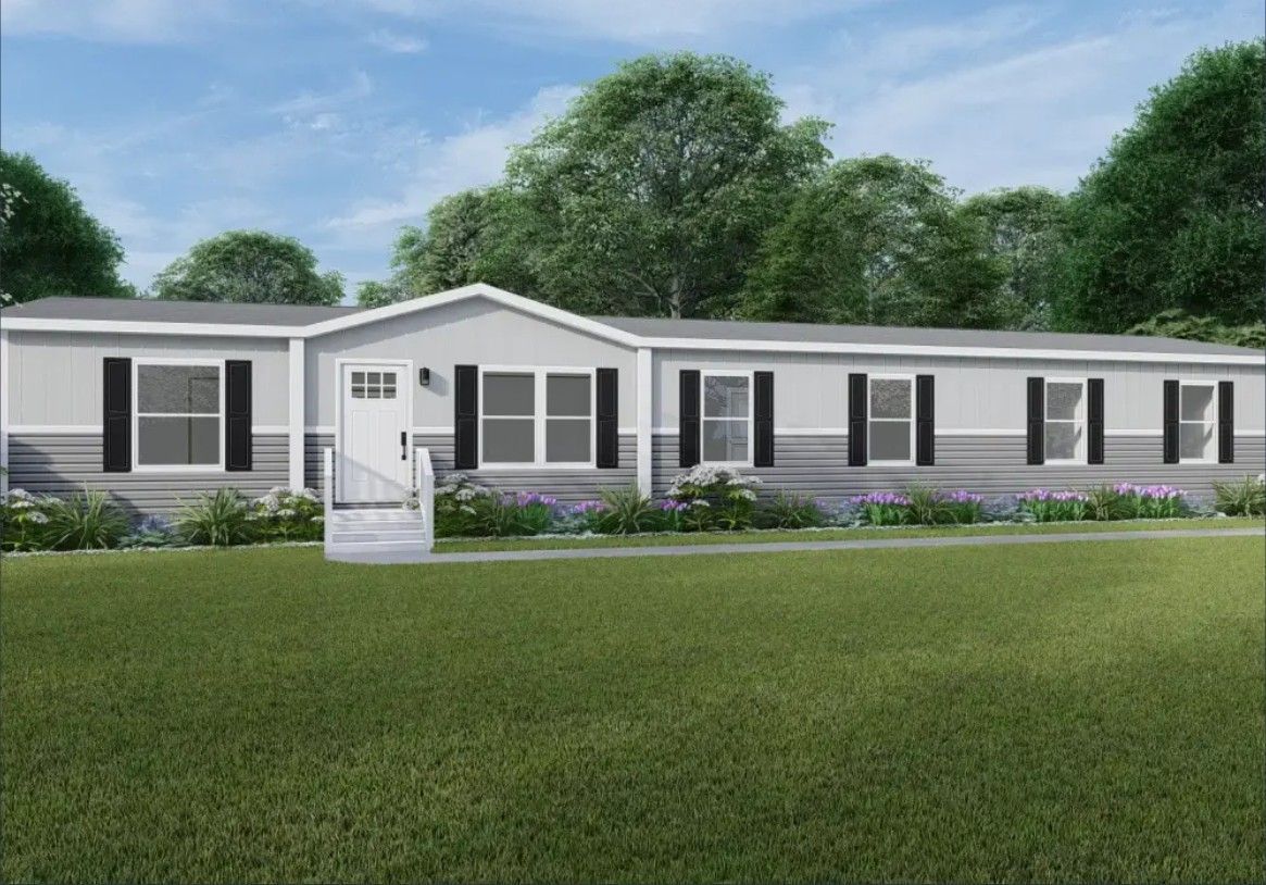 Single-story white house with dark shutters and a front porch, set behind a green lawn under a blue sky
