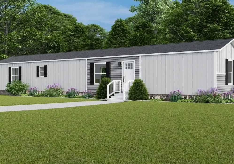 Single-story gray mobile home with white trim and a small front porch, set in a grassy yard.
