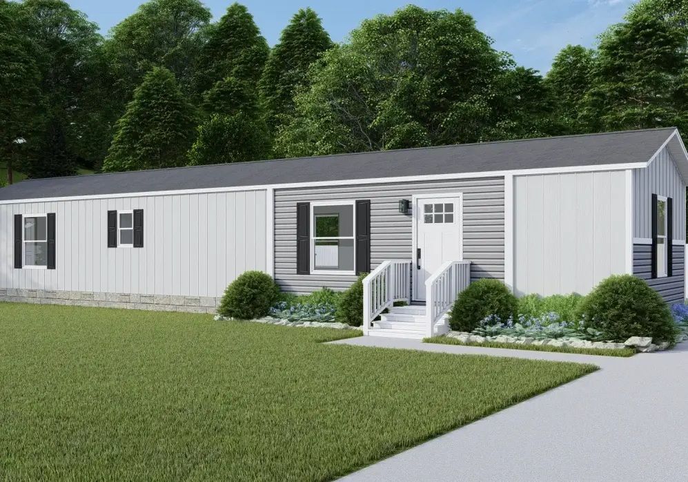 White manufactured home with gray roof, front steps, and shrubs on a green lawn
