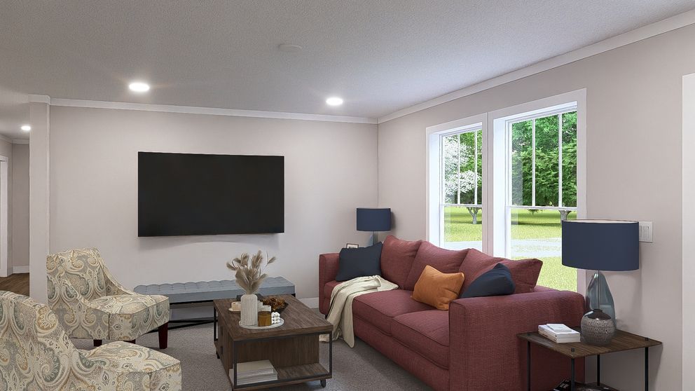 Bright living room with wall-mounted TV, red sofa, armchair, coffee table, and two blue lamps near large windows.