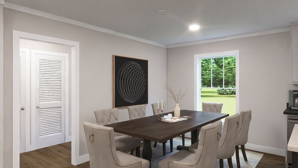Dining room with dark wood table, beige chairs, wall art, and a view of the green backyard through a window.
