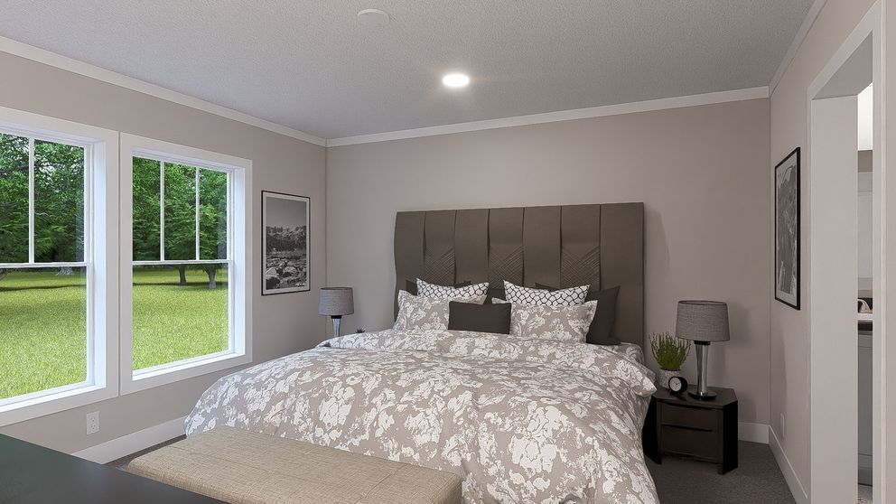Bright bedroom with a large bed, gray walls, and windows overlooking a green lawn.