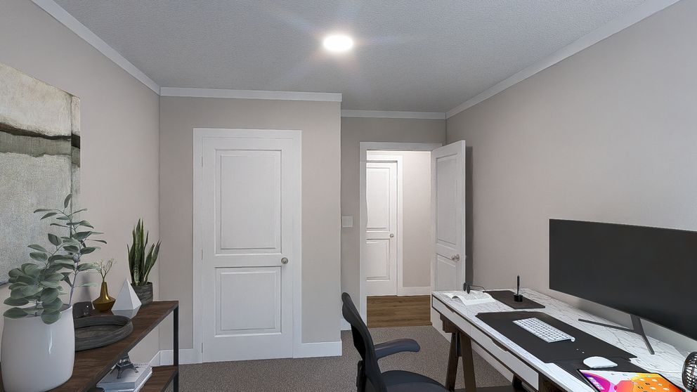 Modern home office with desk, computer monitor, chair, and white doors in a gray room.