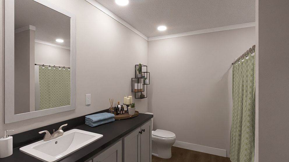 Modern bathroom with sink, mirror, toilet, and green shower curtain in light gray tones