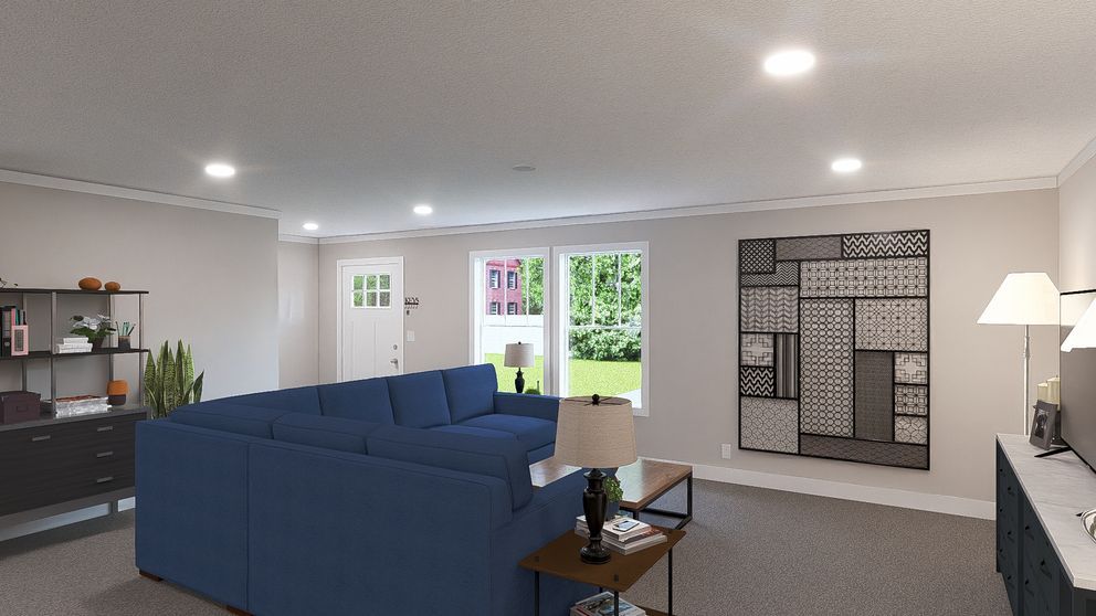 Bright living room with blue sectional sofa, wall art, lamp, and open French doors to a garden.