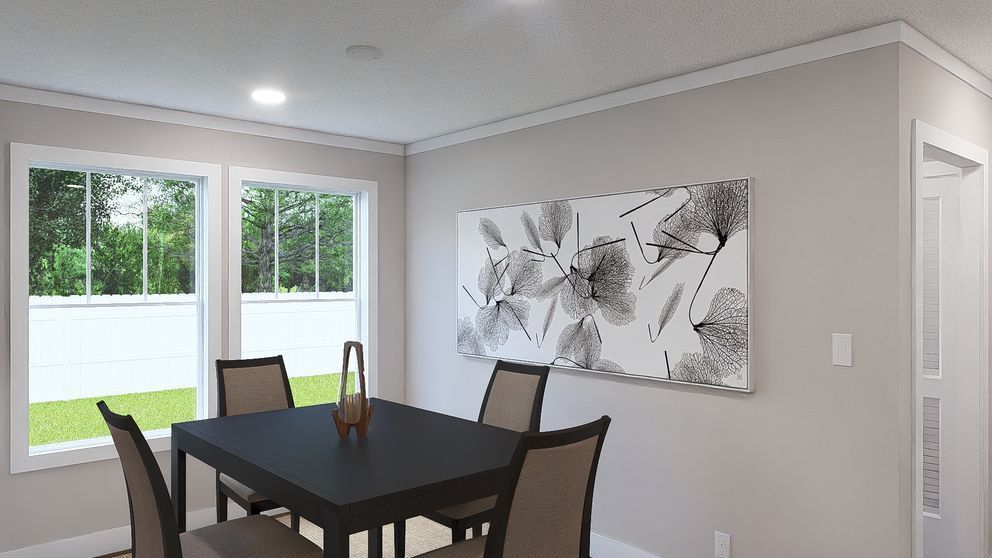 Dining area with dark table and chairs beside bright windows and abstract wall art.