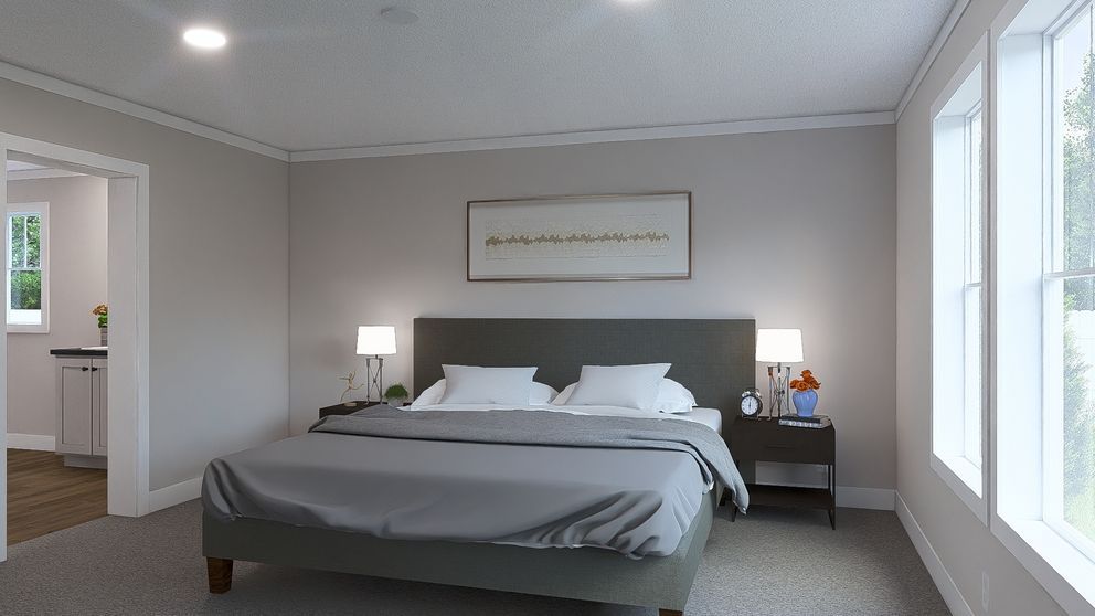 Bright bedroom with a neatly made bed, bedside lamps, and large windows letting in daylight.