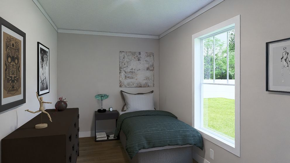 Small bedroom with a bed, dresser, wall art, and a bright window overlooking greenery.
