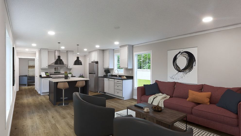 Open-concept living room and kitchen with dark sofa, island, and pendant lights