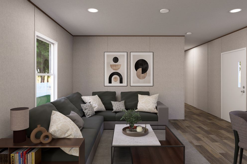 Modern living room with gray sectional sofa, coffee table, wall art, recessed lighting, and wood flooring.