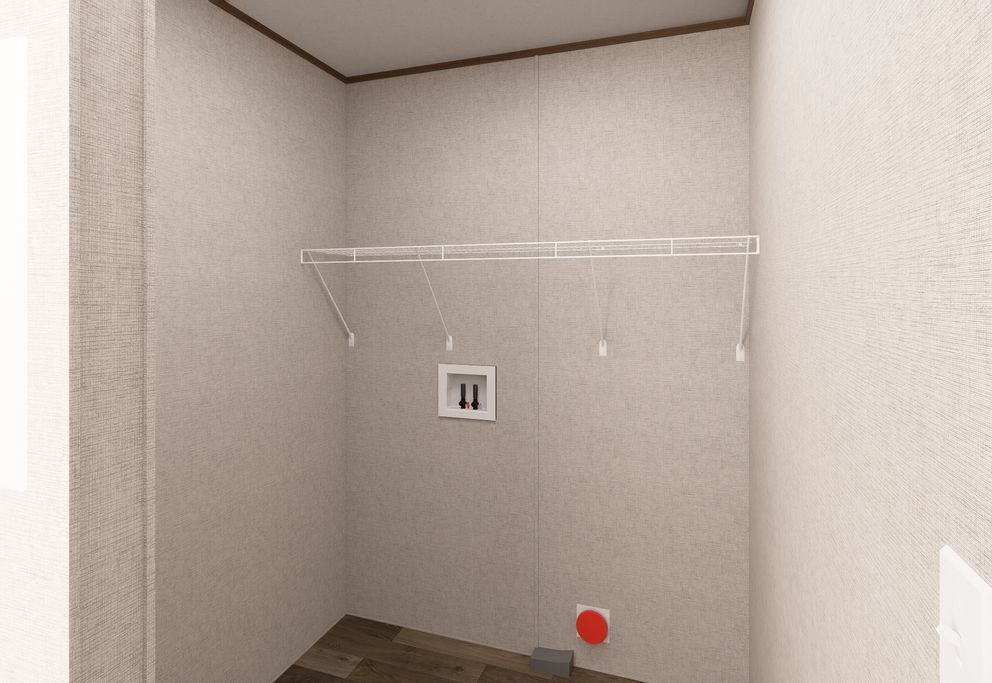 Empty walk-in closet with white walls, shelf, and hanging rod over a dark wood floor.