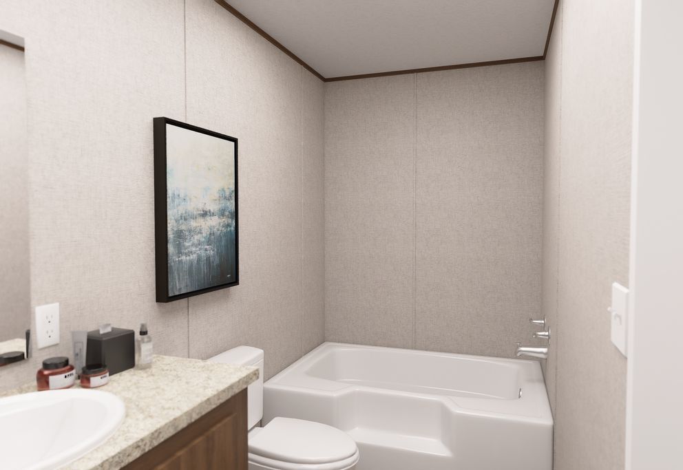 Minimal bathroom with white tub, toilet, granite sink, and framed wall art