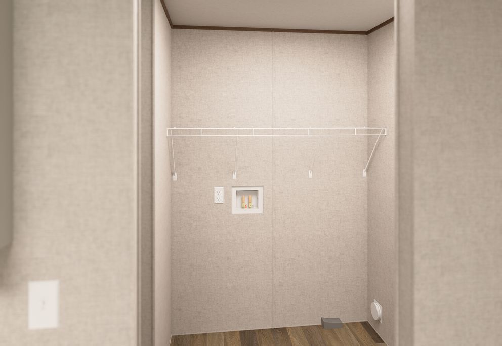 Empty beige closet with a white shelf and wood floor.