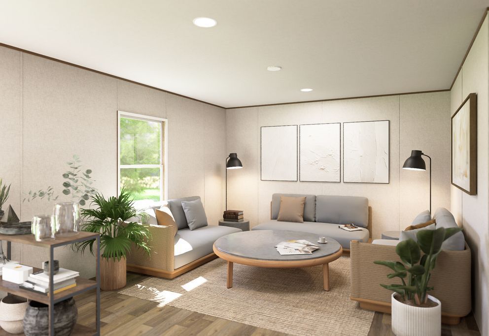 Bright modern living room with beige sofa, round coffee table, plants, and large window light