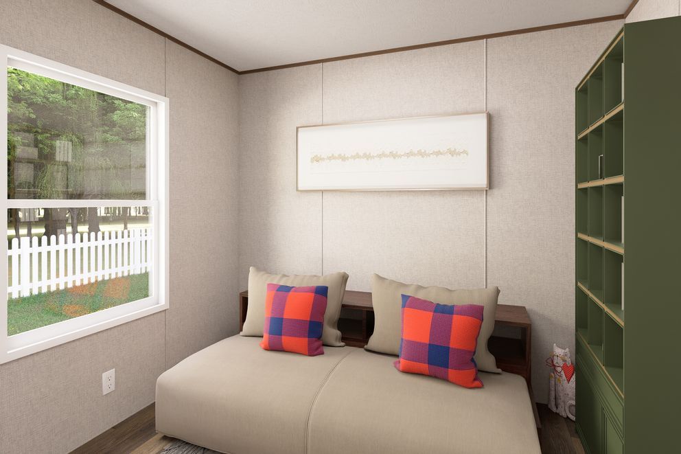 Small bedroom with two beds, plaid pillows, a window, and a tall green bookshelf.