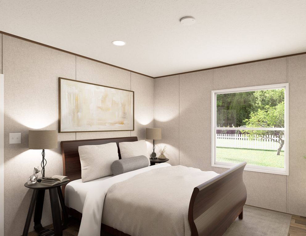 Bright modern bedroom with a bed, bedside lamps, wall art, and a window overlooking greenery.