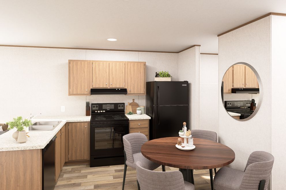 Modern kitchen and dining area with wood cabinets, black stove, round table, and wall mirror