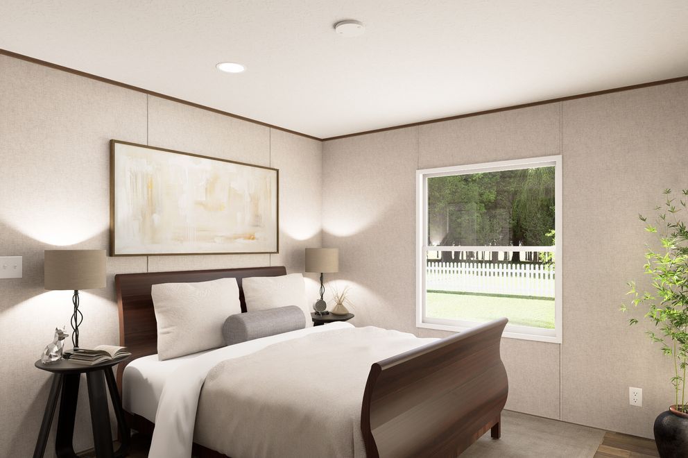 Modern bedroom with a bed, bedside lamps, wall art, and a window overlooking greenery