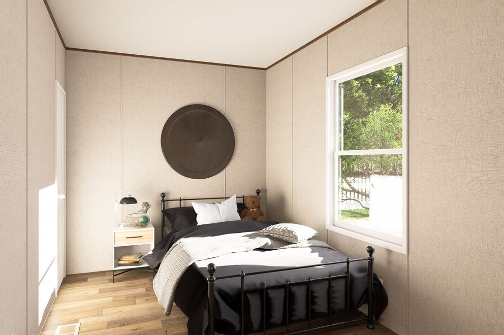 Minimal bedroom with black bed, round wall art, and a bright window.