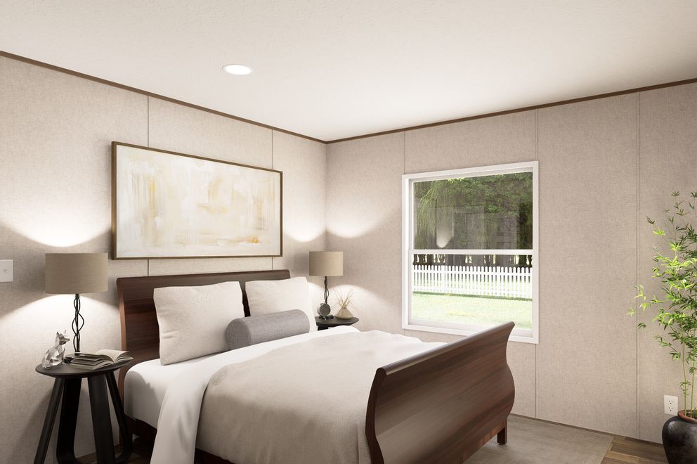 Modern bedroom with a bed, bedside lamps, framed art, and a window overlooking greenery.