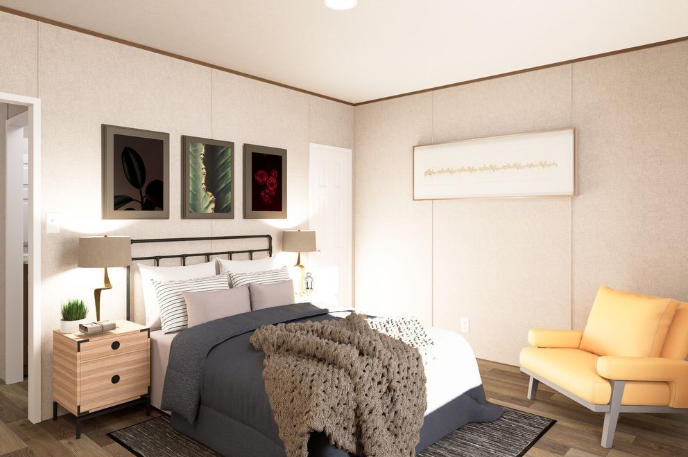 Bright bedroom with a bed, bedside table, wall art, and a yellow armchair in warm sunlight