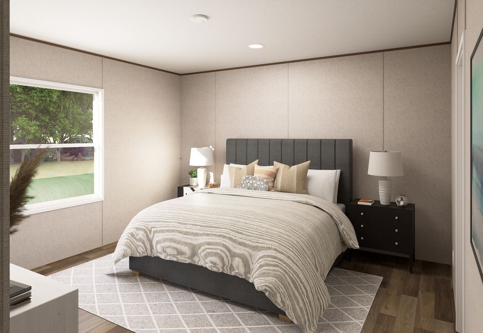 Modern bedroom with a gray bed, bedside lamps, and a window letting in daylight