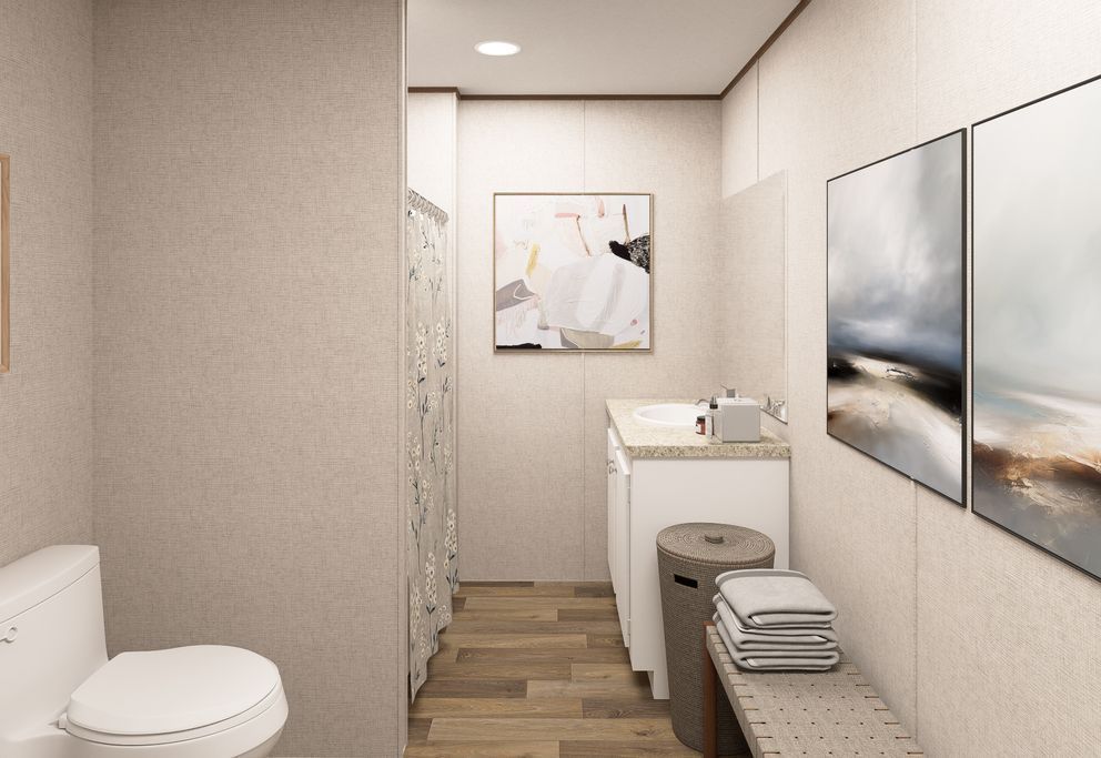 Narrow modern bathroom with toilet, sink, bench, towels, and two wall mirrors.