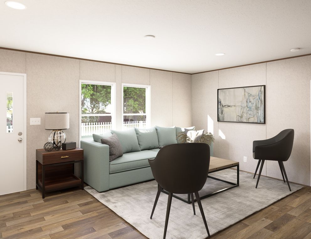 Modern living room with a mint sofa, two black chairs, coffee table, and large windows with natural light
