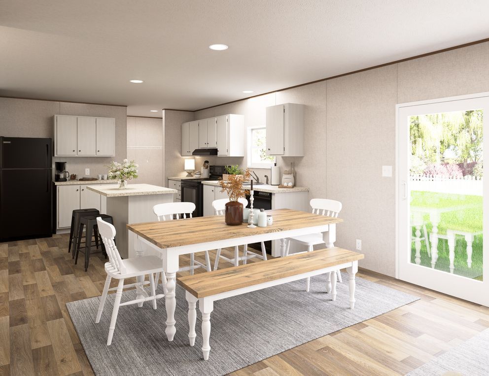 Bright open kitchen and dining area with white cabinets, wooden table, benches, and a rug near a glass door
