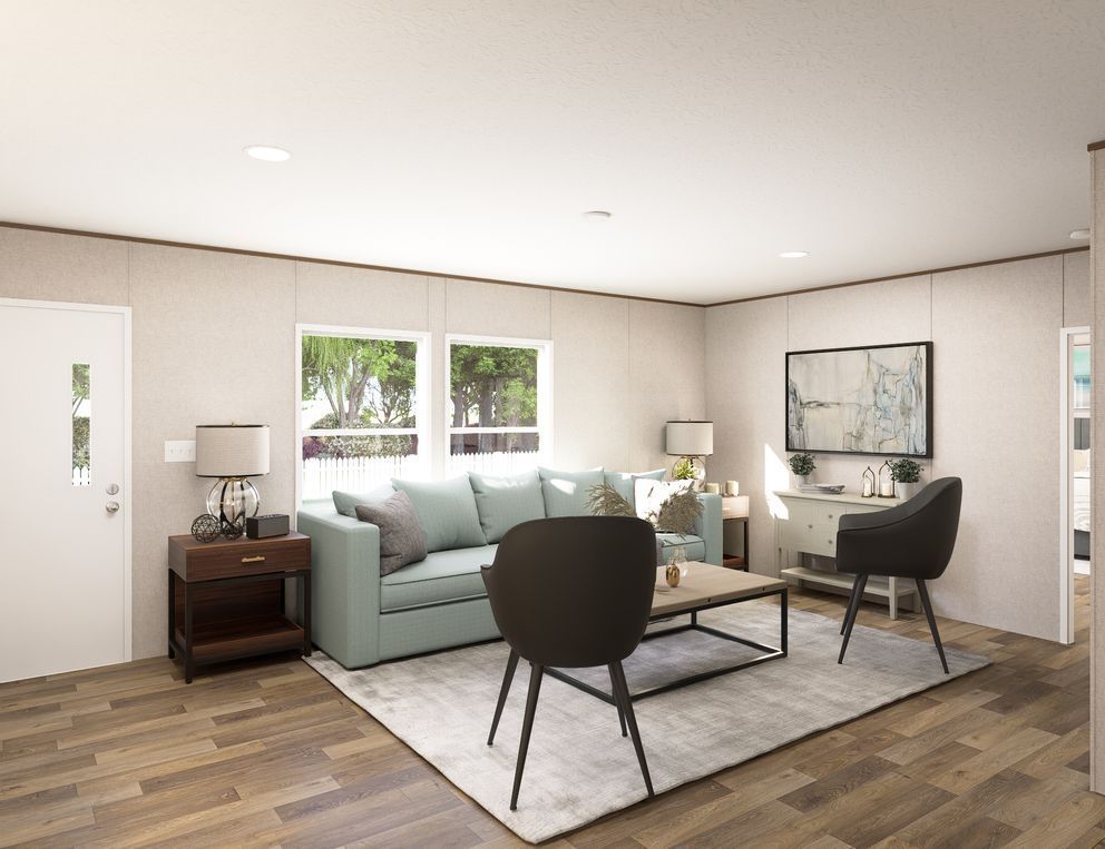 Bright living room with mint sofa, two black chairs, coffee table, rug, and framed wall art.