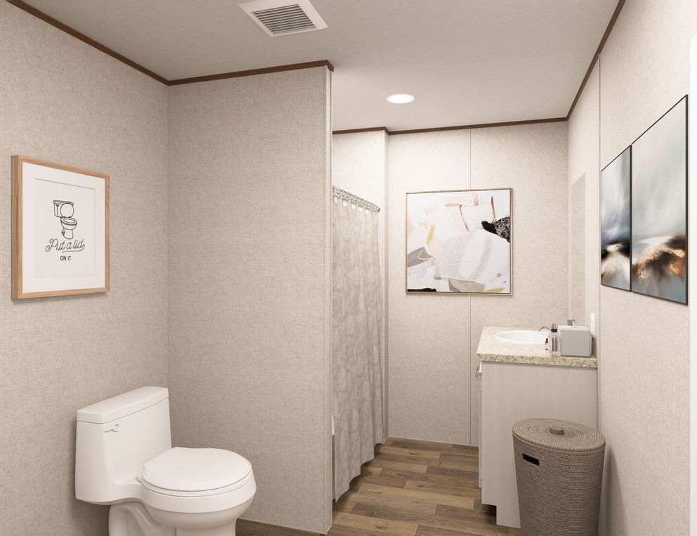 Small bathroom with toilet, shower curtain, sink, and framed wall art in neutral tones