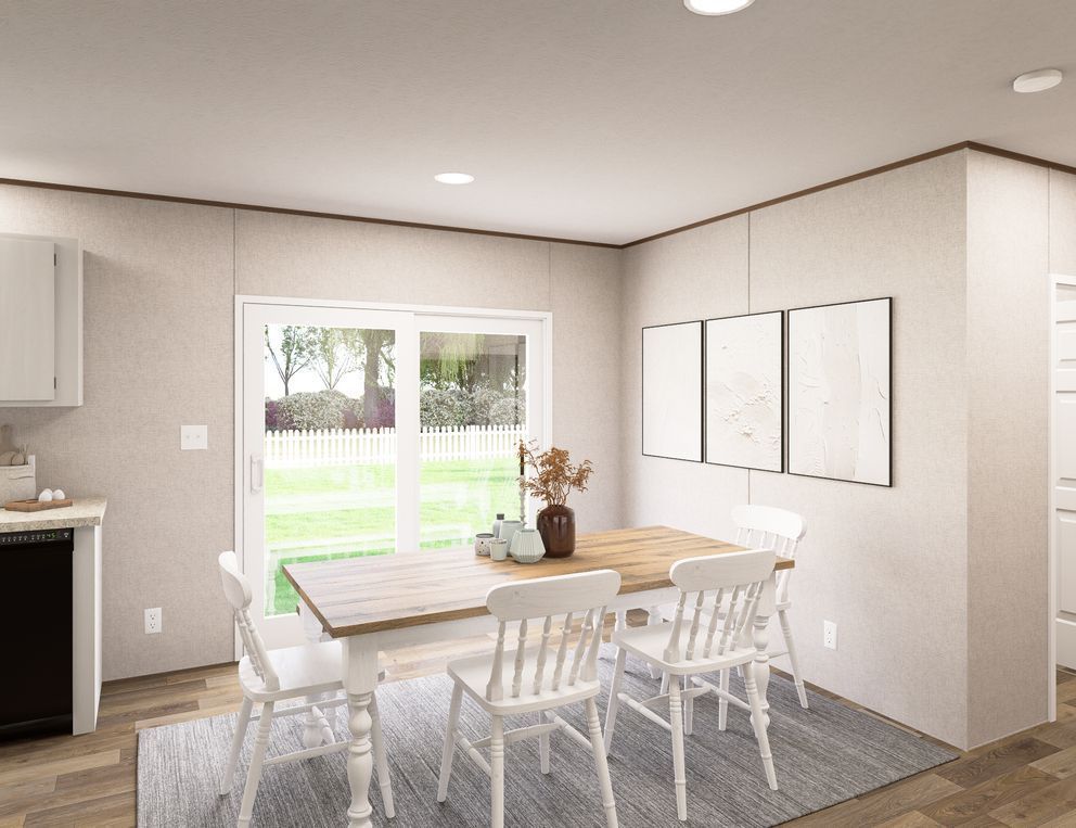 Bright dining area with white table, chairs, large window, and light wood floors overlooking a backyard.