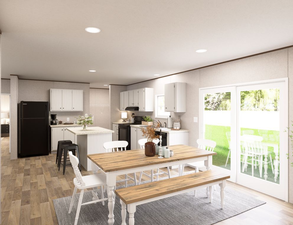 Bright modern kitchen and dining area with white cabinets, wooden table, and sliding glass doors to a patio