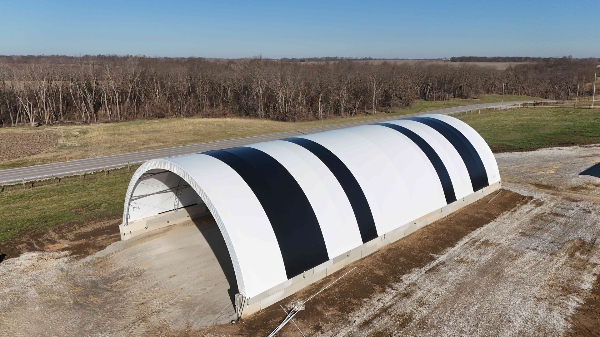 White arched structure with black bands in a field.