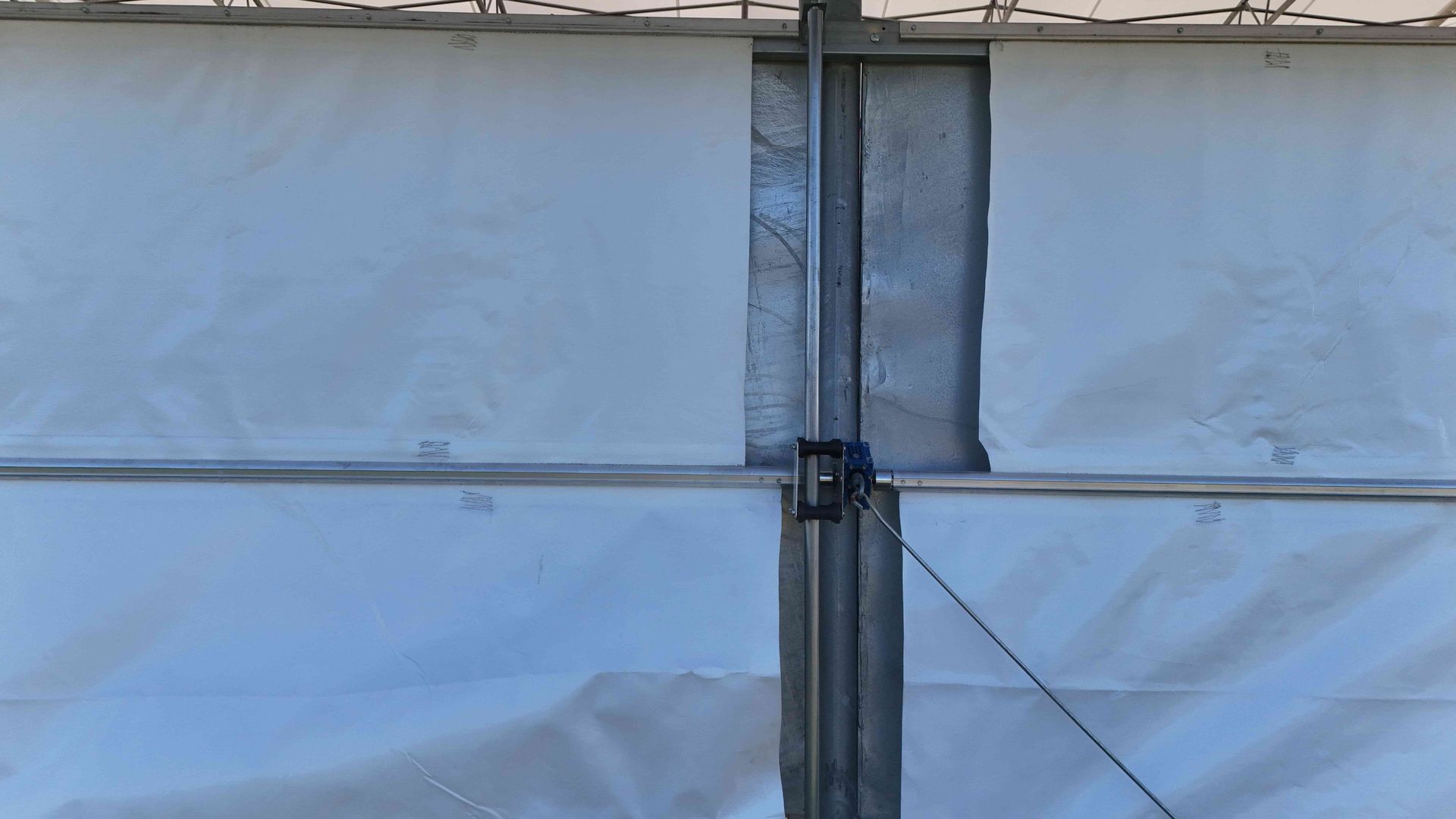White tent panels with metal framing and a cable.
