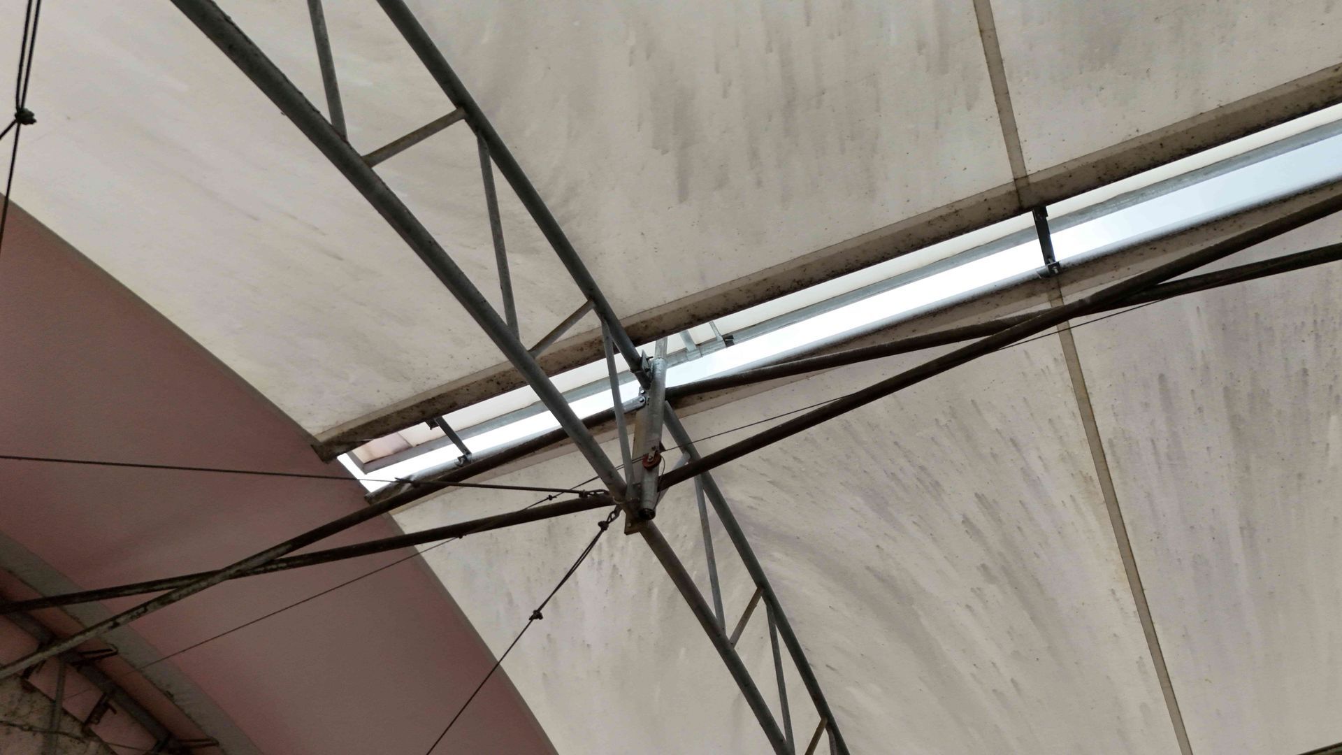 White canopy ceiling with a metal support structure and a fluorescent light.