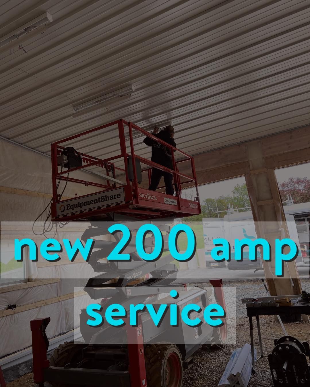 Person on lift installing a light fixture on a ceiling