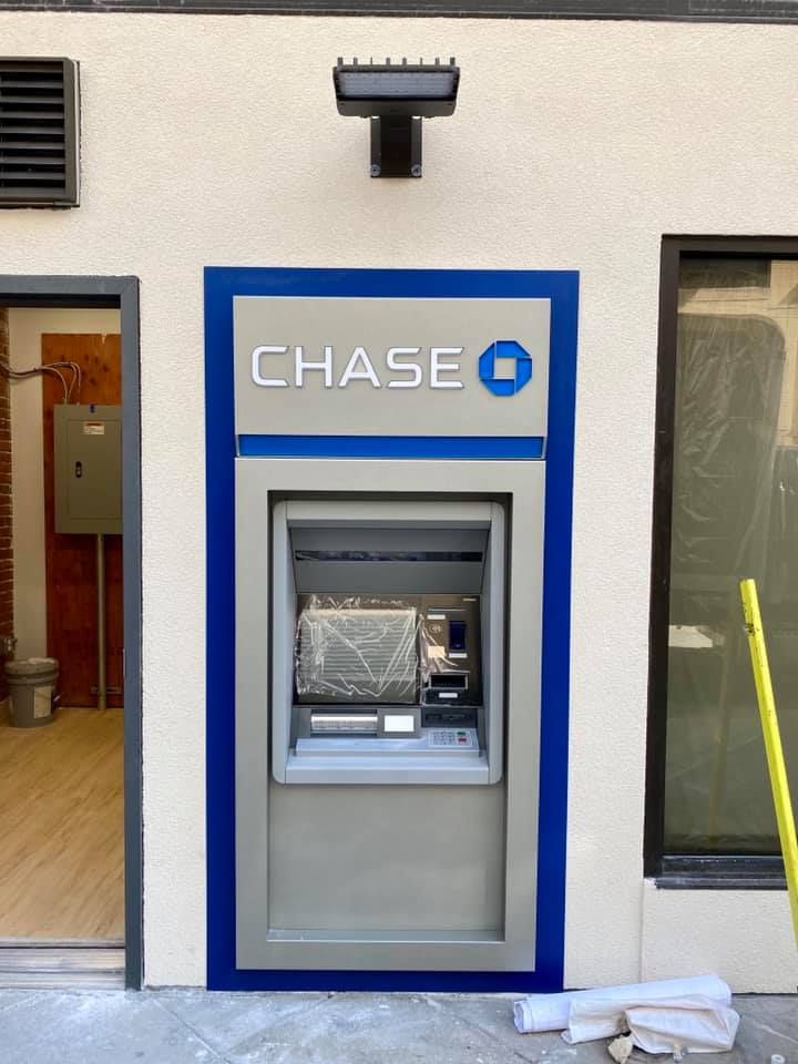 Chase ATM encased in blue and silver frame, mounted in a wall.