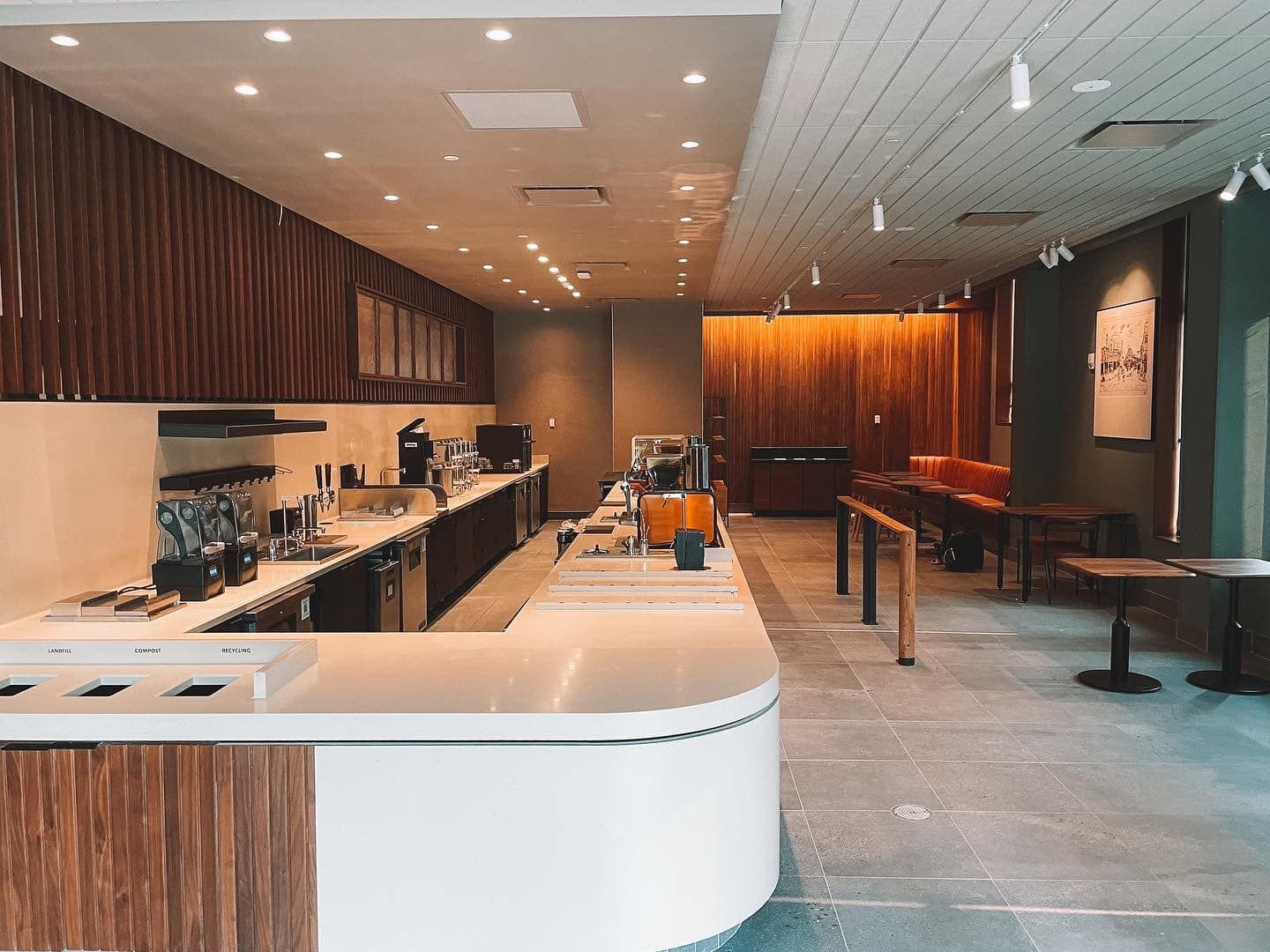 Coffee shop interior with a white counter and wood paneling.