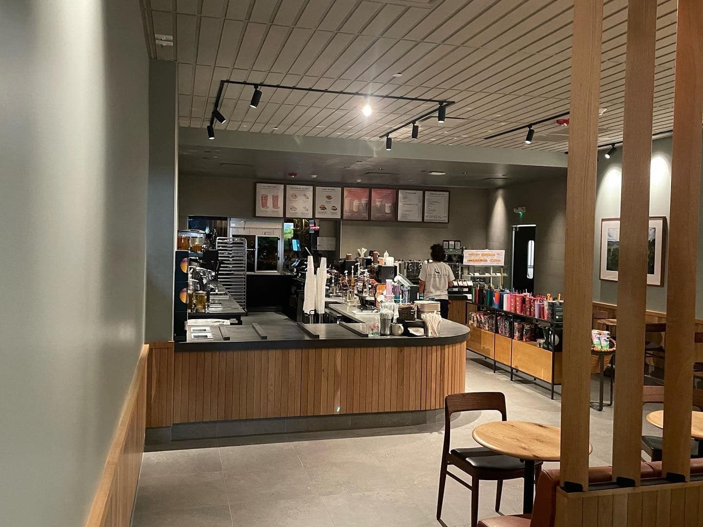 Interior view of a Starbucks cafe with customers and baristas behind the counter. 