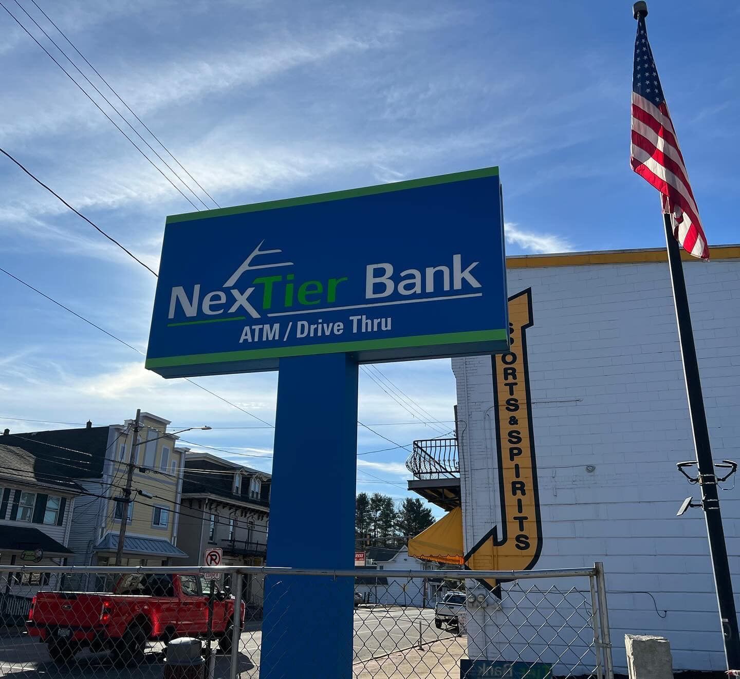 NexTier Bank sign next to a building with a Sports & Spirits sign.