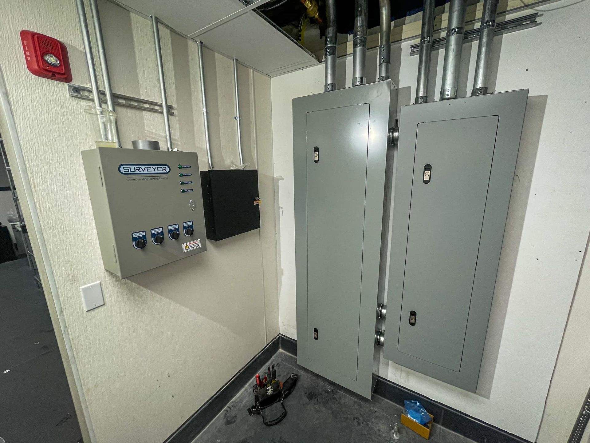 Electrical control panels and conduit on a wall in a room. 