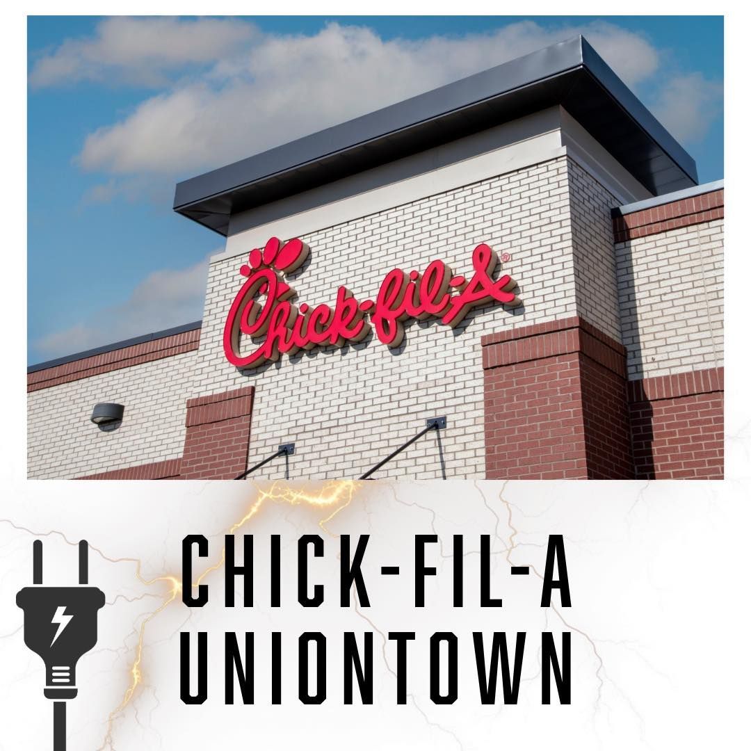 Chick-fil-A Uniontown restaurant exterior with red logo on brick facade and blue sky.
