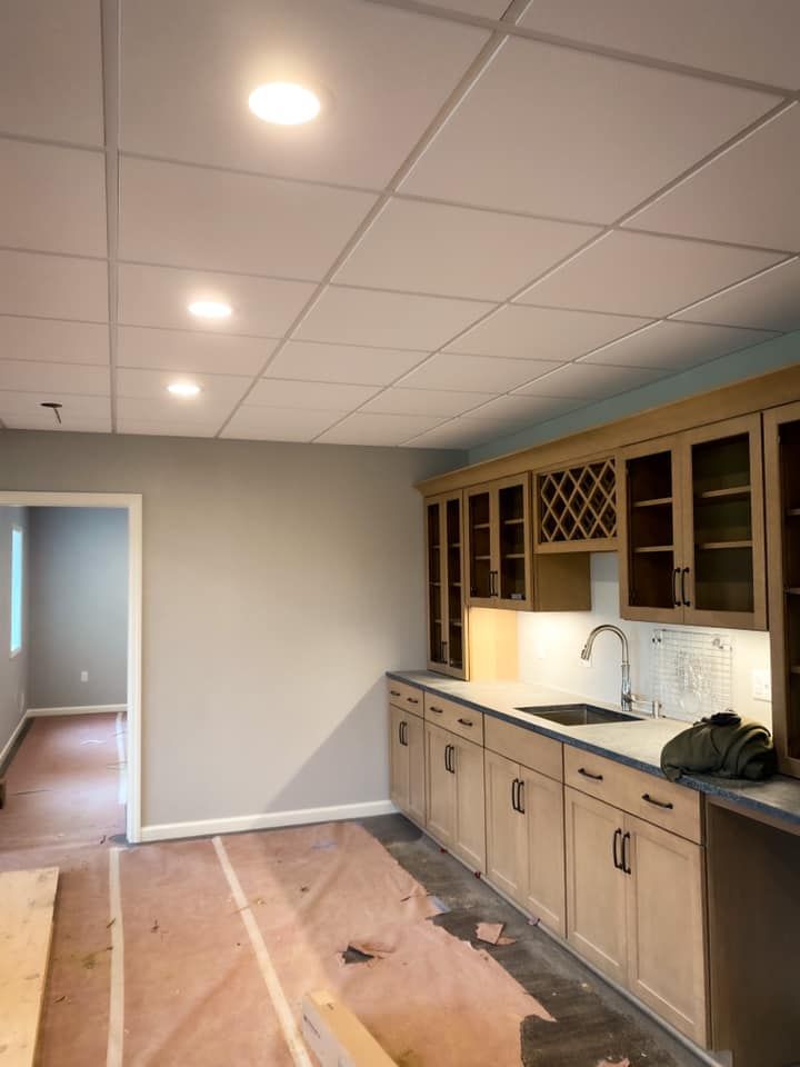 Kitchen with light wood cabinets, gray walls, and recessed ceiling lights.