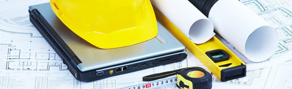 Contractor tools with a laptop and blueprints