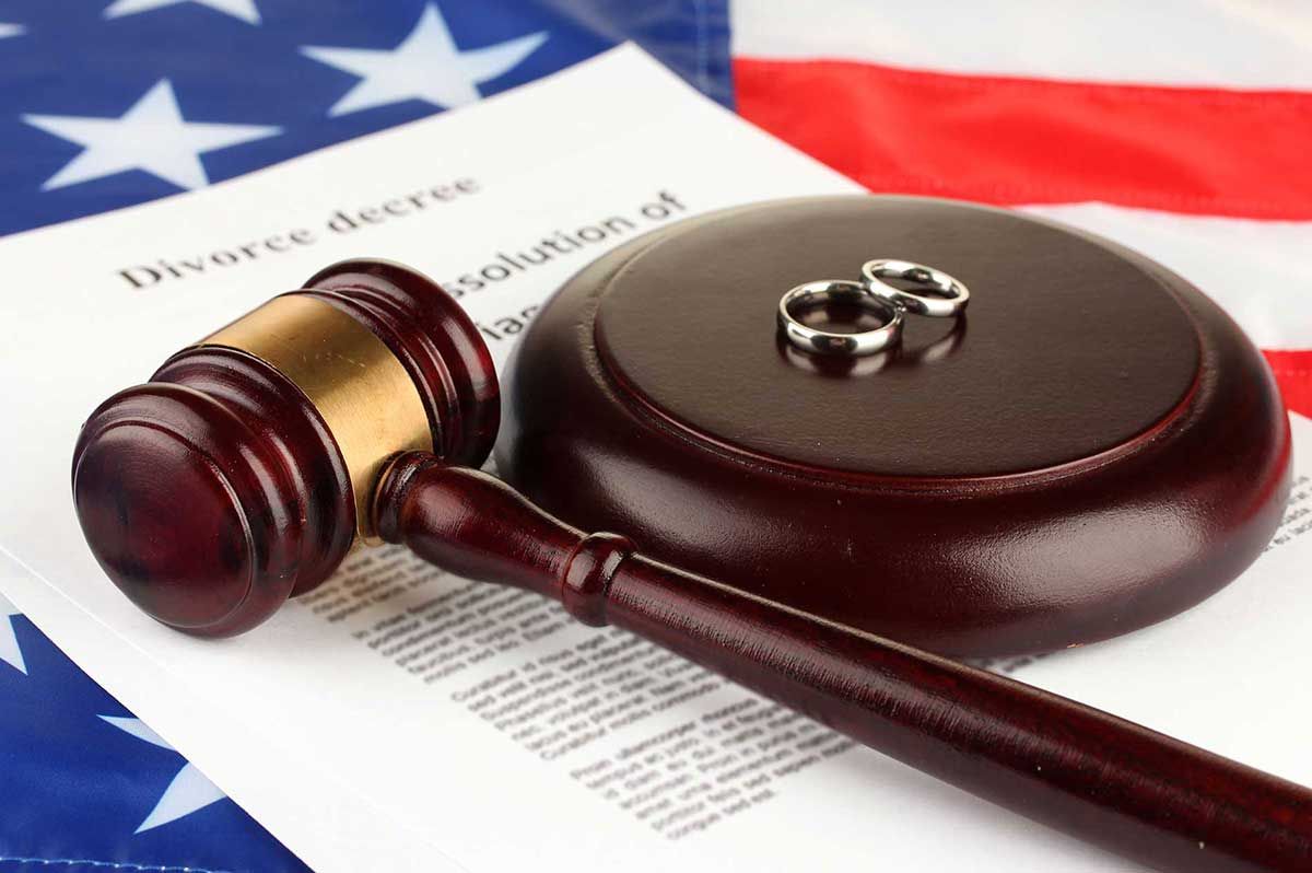 a pair of wedding rings sit on top of a divorce decree